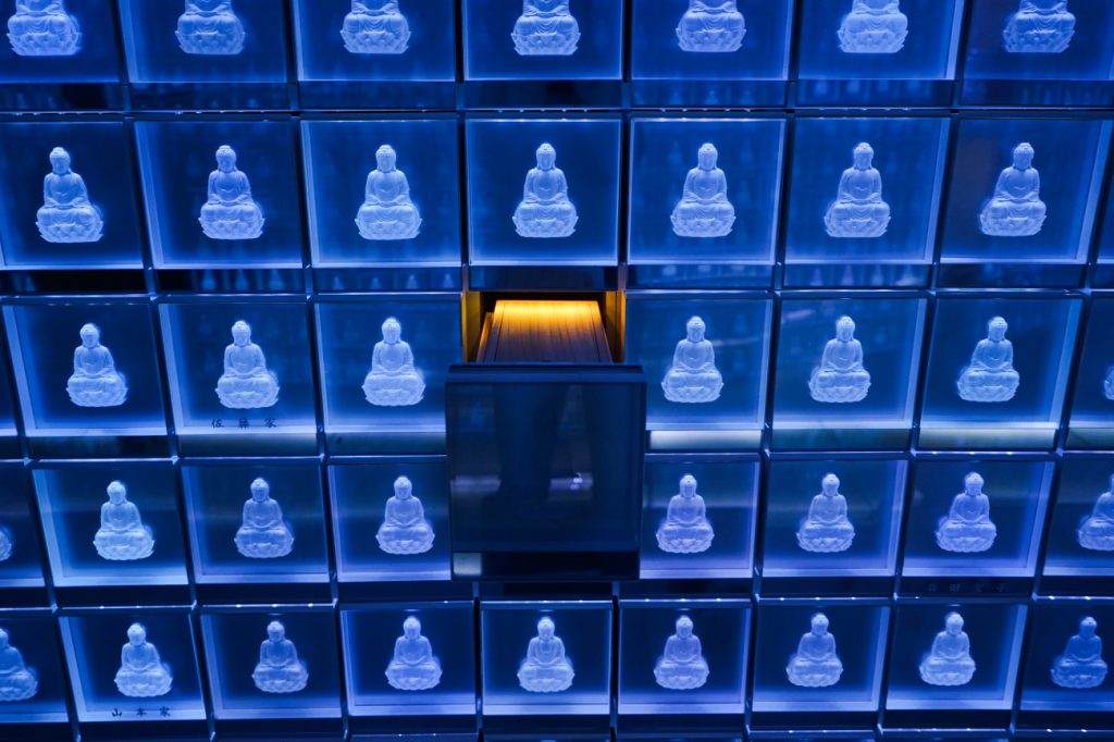 A wooden container that has bones and ashes in a drawer at the Banshoji temple in Nagoya city, there are sinerarias in the main building. On the 3rd floor, there is a crystal place called Suishoden. In this hall, blue LED (light-emitting diodes) illuminate 2,000 small glass containers stacked along the hall's walls, each container is decorated with an image of the Buddha. A visitor put an electronic identity card at the entrance and the appropriate urn lights up in gold. Regardless of the religious sect memorial services are held.